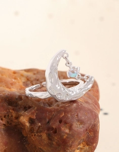 Detail shot of hammered S925 silver moon ring featuring a hanging moonstone charm