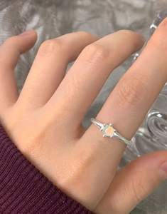Dettaglio di un anello in argento S925 con una pietra opale rotonda dal riflesso unico