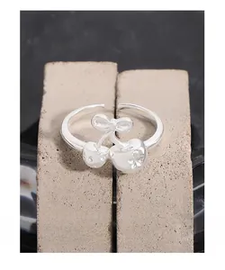 Macro shot of S925 silver cherry ring with bow and cubic zirconia on stone base