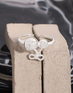 Macro shot of silver bow cherry ring with star carvings and cubic zirconia details