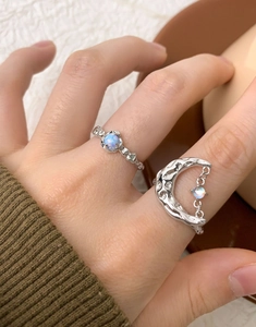 Lava texture crescent moon ring with opal gemstone on model hand with knit sweater
