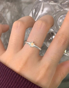 Dettaglio dell'anello in argento S925 con opale e castone a sei griffe sulla mano