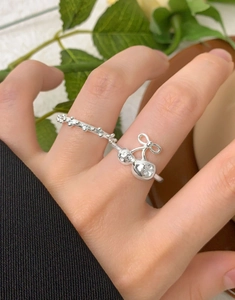Macro view of S925 silver ring featuring cherry and bow design with textured finish