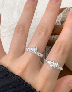 Close-up of S925 silver rings with oval zircon and heart-shaped pink stones on a model hand