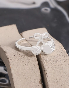Macro detail of S925 silver bow cherry ring featuring sparkling zircon stones