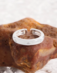 Macro detail of S925 sterling silver star ring with inlaid zircon on natural stone