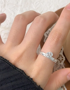 Detail showing an oval clear zircon stone on a flat S925 sterling silver ring band