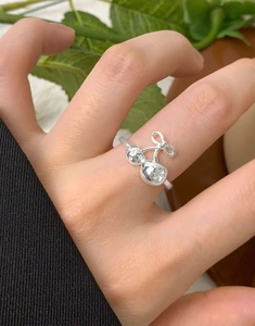 Close-up of S925 silver ring featuring cherry and bow design worn on finger