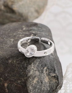 Close-up of S925 sterling silver ring with oval zircon on dark textured stone
