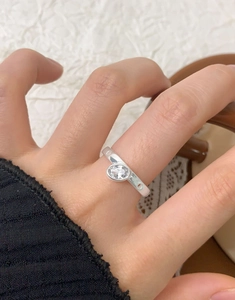 Detailed view of an oval zircon silver ring on a finger with a minimalist design