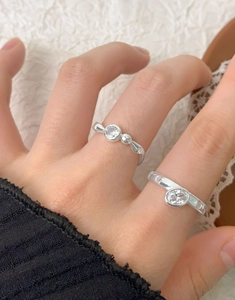 Detail view of S925 sterling silver rings with oval zircon on a model's finger