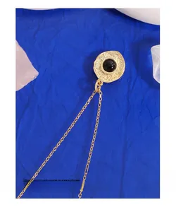 Detail of gold necklace featuring black agate pendant on a textured hammered metal base