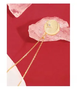 Detailed view of gold starburst necklace with zircon pendant on a luxury background