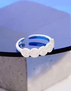 Macro shot of silver S925 floral ring with intricate daisy details on blue background