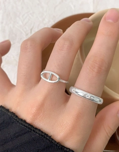 Close-up of S925 sterling silver ring set featuring star engraving and chain link design