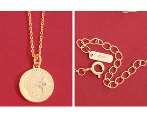 Detail of S925 sterling silver stamp on golden starburst pendant and necklace chain