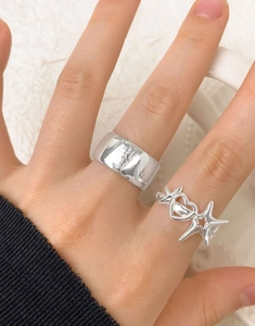 Detail of silver S925 rings featuring a wide star band and heart star design