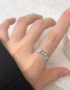 Detail view of a minimalist S925 silver wave ring with a polished mirror finish on a finger