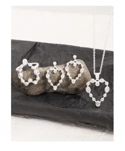 Detail of silver S925 heart jewelry set with zircon necklace, ring, and earrings