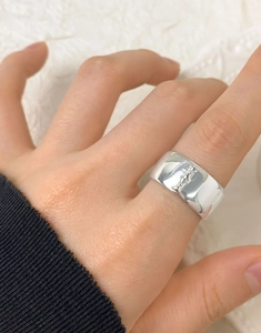 Macro shot of wide S925 sterling silver ring featuring a detailed embossed motif