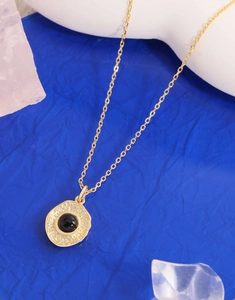 Detail of S925 silver necklace with gold plated irregular pendant and black onyx inlay