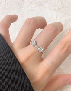 Detail of S925 sterling silver ocean wave ring with heart knot on lace background