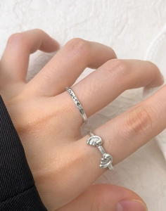 Detailed view of silver S925 rings featuring a Smile engraving and a twisted knot design