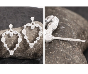 Vue macro du poinçon S925 sur des boucles d'oreilles cœur en argent et zircon