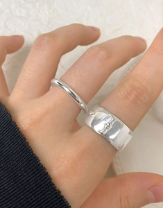 Detail of S925 silver ring set with embossed vintage pattern and smooth band on finger