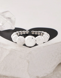 Macro detail of S925 silver open ring featuring polished beads and a frosted sand sphere