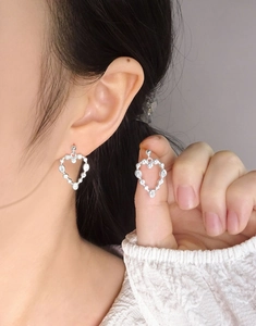 Gros plan de boucles d'oreilles coeur en argent S925 avec zircons étincelants