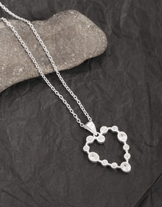 Close-up of S925 sterling silver heart necklace with zircon inlay on natural stone