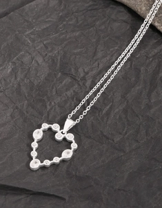 Detailed view of S925 silver heart pendant with sparkling cubic zirconia on grey background