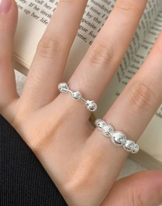Detail of S925 silver rings with gradient beads and star design on a book background