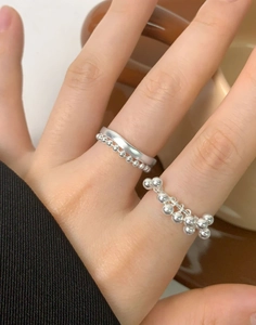 Dettaglio del set di anelli con perline in argento S925 sulla mano con frange