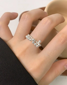 Dettaglio ravvicinato dell'anello con perline in argento S925 a forma di uva indossato