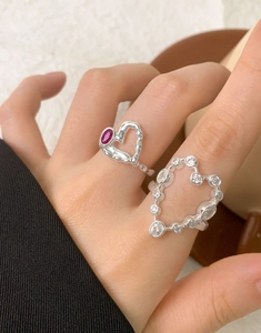Detailed close-up of S925 silver rings with red oval stone and white zircon heart shapes