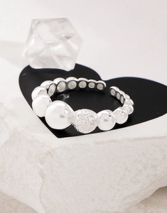 Macro detail of S925 sterling silver ring with textured bubble design and open band