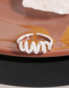 Gros plan du poinçon S925 sur la bague minimaliste en argent avec motif spirale