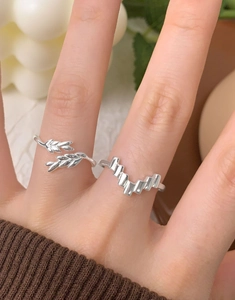 Detailed close-up of S925 sterling silver geometric and leaf-shaped rings on finger