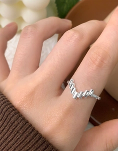 Macro shot of silver S925 geometric zigzag ring with V-shape irregular pattern on finger