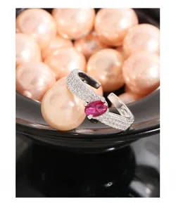 Macro shot of silver ring with fuchsia zircon gemstone against lush pearl background
