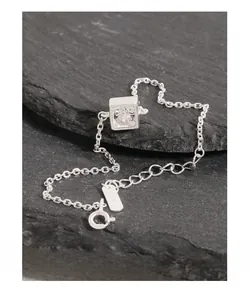 Gros plan sur bracelet en argent S925 avec zircon carré sur une plaque de pierre