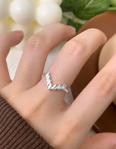 Detail shot of irregular silver S925 geometric wavy ring worn on index finger