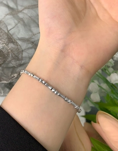 Macro detail of S925 sterling silver beaded bracelet with geometric faceted bars and beads