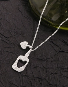 Détail du collier argenté S925 avec pendentifs double cœur martelés sur fond noir élégant