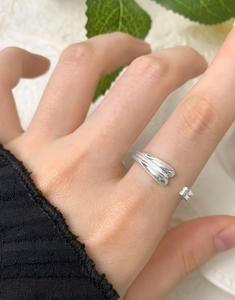 Detail of a minimalist 925 silver double-layered teardrop open ring on a model hand