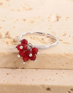 Macro view of silver adjustable ring featuring red faceted beads and textured metal details