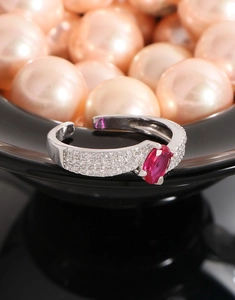 Macro shot of a S925 silver open ring featuring a magenta zircon and pavé diamonds