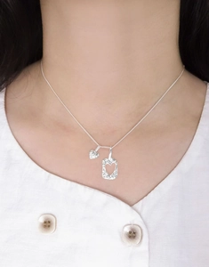 Détail du collier en argent S925 avec pendentifs double cœur et texture martelée